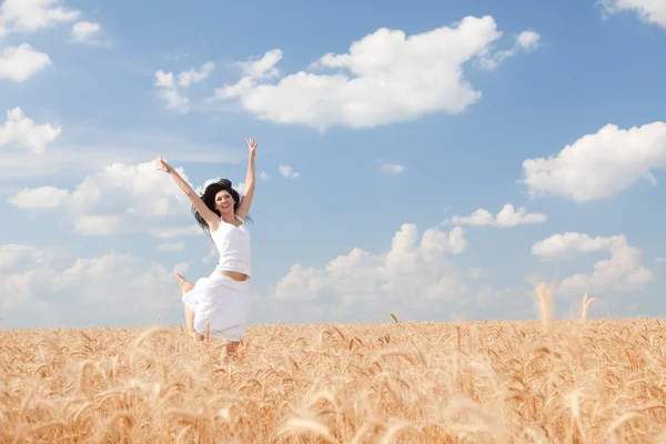 Mujer feliz saltando en trigo dorado —  Fotos de Stock