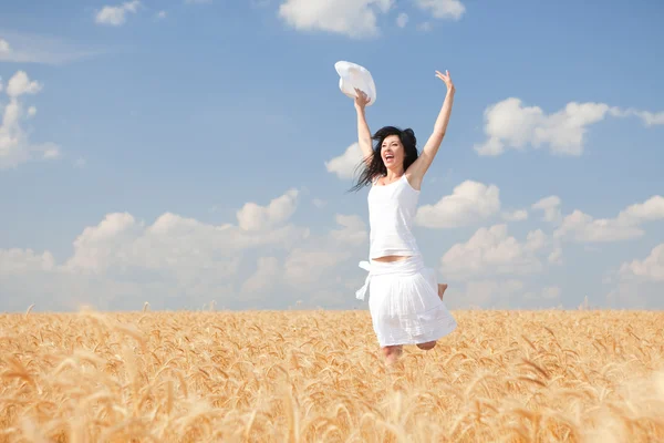 Mujer feliz saltando en trigo dorado — Foto de Stock