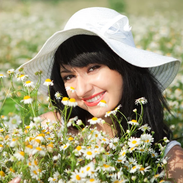 Young happy girl in the romomile field — стоковое фото