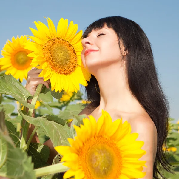 Junge Frau im Feld der Sonnenblumen — Stockfoto