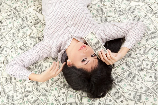 Young business woman resting upon money — Stock Photo, Image
