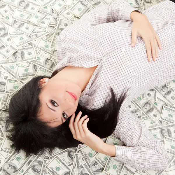 Молодая деловая женщина, опирающаяся на деньги — стоковое фото