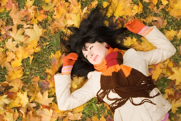 Unga vackra kvinnan på hösten blad — Stockfoto