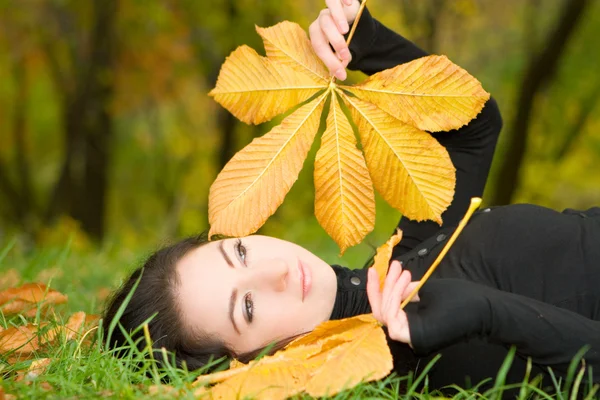 Young pretty woman with autumn leaf — Stock Photo, Image