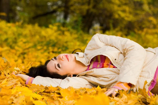 秋天的叶子上年轻漂亮的女人 — 图库照片