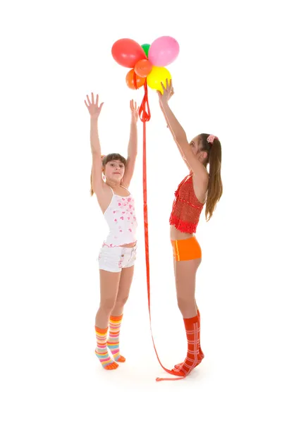 Twee gelukkige meisje met kleuren ballonnen — Stockfoto