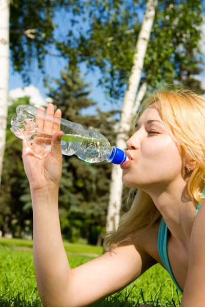 在夏天林间空地上的漂亮女人喝水 — 图库照片