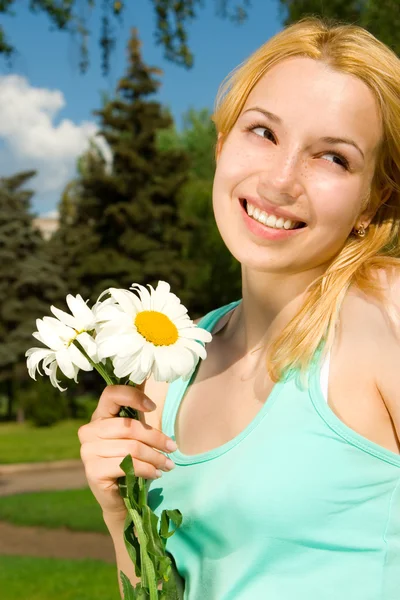 Spaßfrau rastet im Park mit Blumen aus — Stockfoto