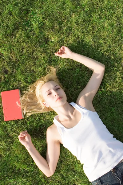 Jeune blonde avec livre dans le parc — Photo