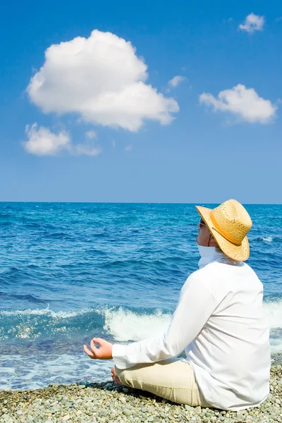 Man with hat meditation in the beach — Stock Photo, Image