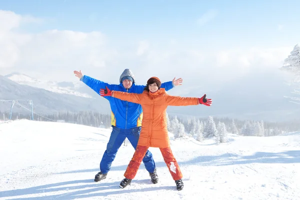 Lyckliga paret med ski i vinterlandskapet — Stockfoto