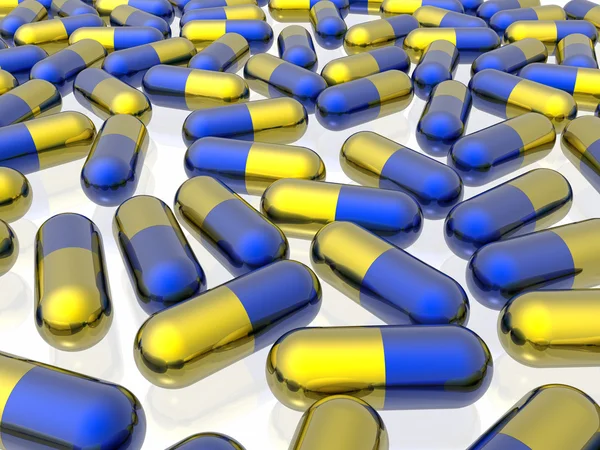 Pílulas azuis e amarelas no fundo branco — Fotografia de Stock