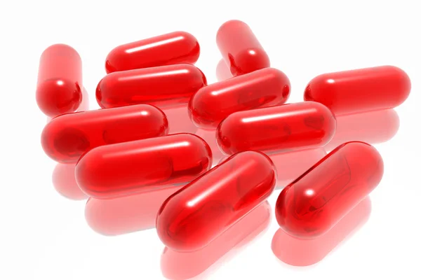Píldoras rojas sobre fondo blanco —  Fotos de Stock