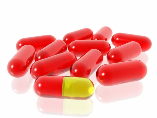 Punainen ja keltainen pillereitä valkoisella taustalla — kuvapankkivalokuva