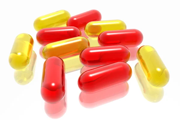 Píldoras rojas y amarillas sobre fondo blanco — Foto de Stock