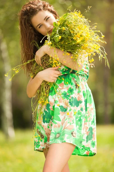 Çiçeklerle parkta genç Kızıl saçlı kadın — Stok fotoğraf