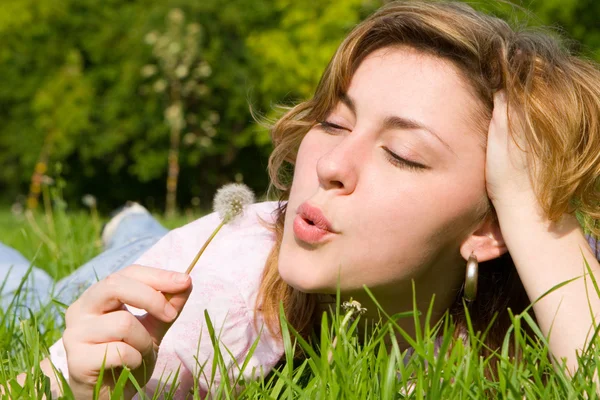 Young girl blowing on the dandelion — Stock Photo, Image