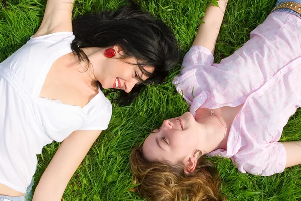 Smiling women rest on the green grass — Stock Photo, Image