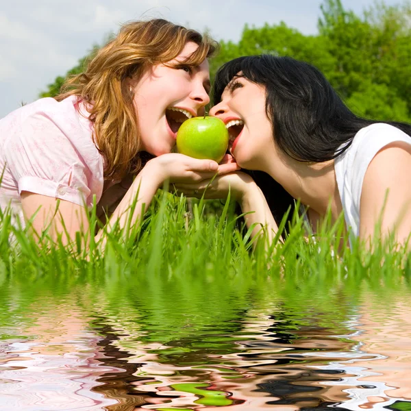 Ładne kobiety jedzenia jabłko na polanie lato — Zdjęcie stockowe