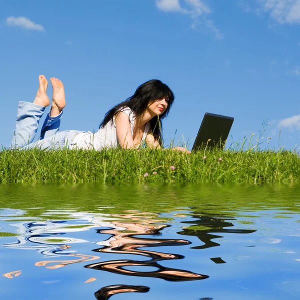 Hübsche Frau mit Laptop im grünen Gras — Stockfoto