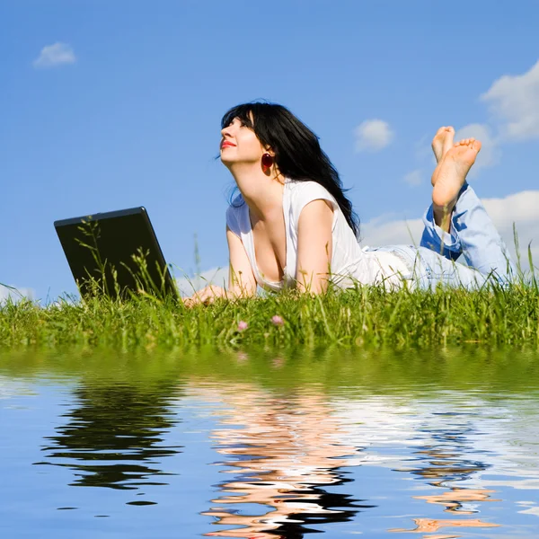 Vacker kvinna med laptop på det gröna gräset — Stockfoto