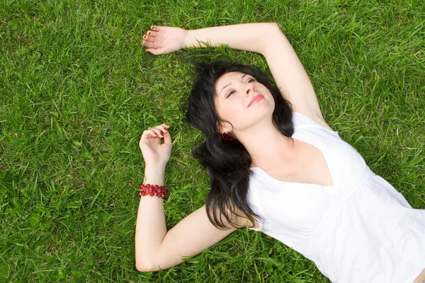 Sladká žena odpočinku na zelené trávě — Stock fotografie