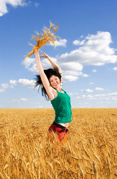 Szczęśliwa kobieta skoki w złotej pszenicy — Zdjęcie stockowe