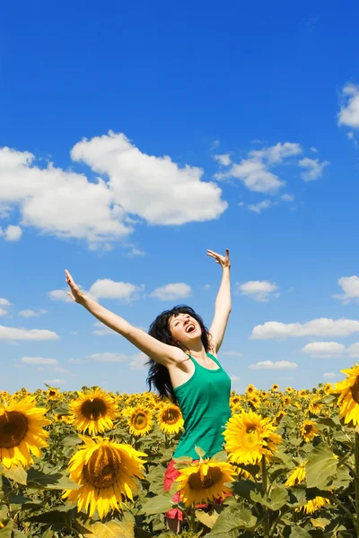Lustige Frau springt in das Feld der Sonnenblumen — Stockfoto