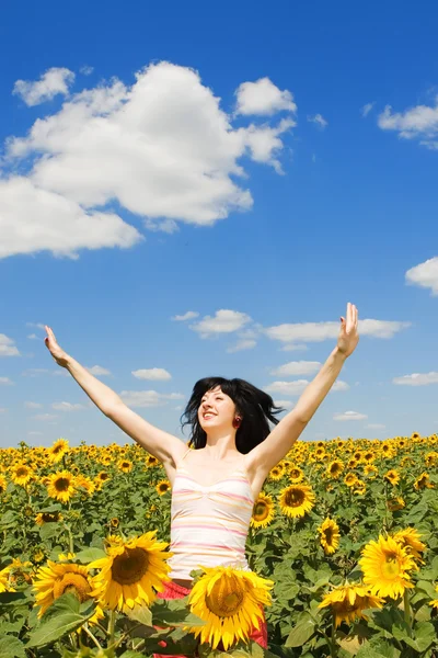 Веселая женщина прыгает в поле подсолнухов — стоковое фото