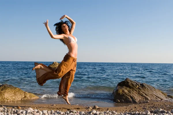 Счастливая молодая женщина танцует на пляже — стоковое фото