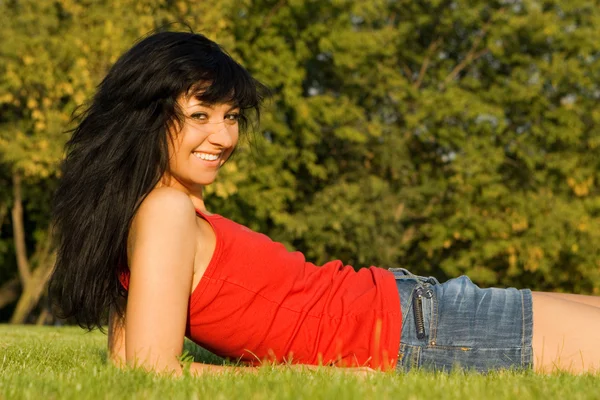 Sladká žena odpočinek v trávě — Stock fotografie