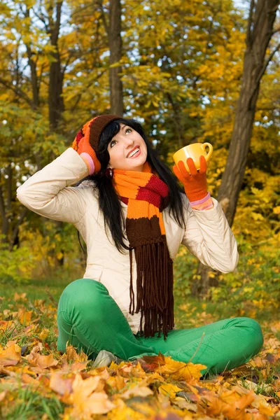 Young pretty woman with tea cup in the autumn park — Stock Photo, Image