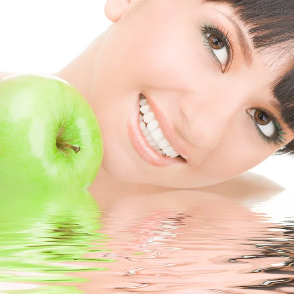Menina doce comer maçã verde no fundo branco — Fotografia de Stock