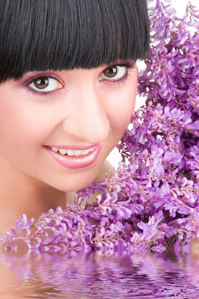 Junge Frau mit lila Blüten — Stockfoto