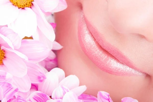 Glimlach van jonge vrouw met bloemen — Stockfoto