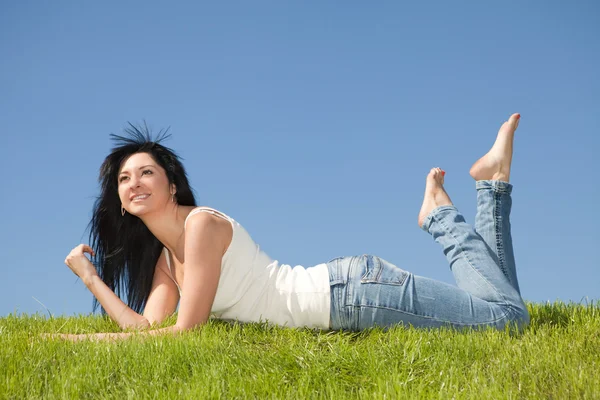 Glückliche junge Frau ruht auf dem grünen Gras — Stockfoto