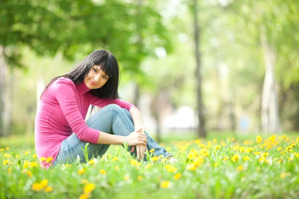 Carina donna nel parco con denti di leone — Foto Stock