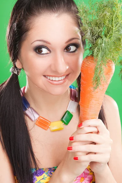 Espressione ragazza con carota sullo sfondo verde — Foto Stock