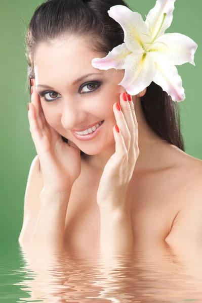 Fiatal nő, liliom virág, zöld háttér — Stock Fotó