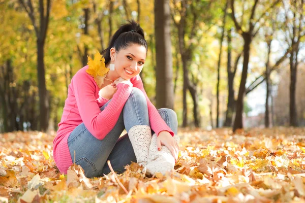 Junge hübsche Frau ruht sich im Herbstpark aus — Stockfoto
