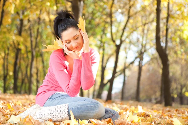 Nuori kaunis nainen levätä syksyllä puistossa — kuvapankkivalokuva