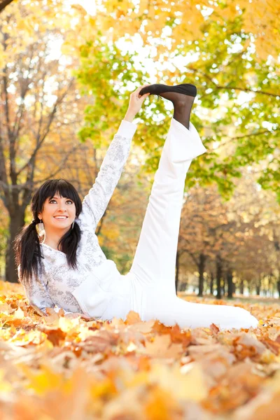 Vacker kvinna gör yogaövningar i höst park — Stockfoto