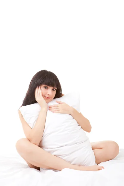 Cute woman fights pillow on the white bed — Stock Photo, Image