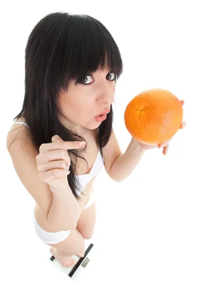 Веселая женщина с апельсином на стеклянных весах — стоковое фото