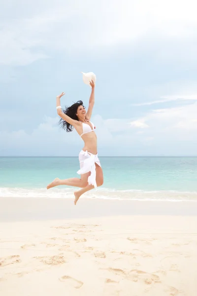Szczęśliwa młoda kobieta, skoki na plaży — Zdjęcie stockowe
