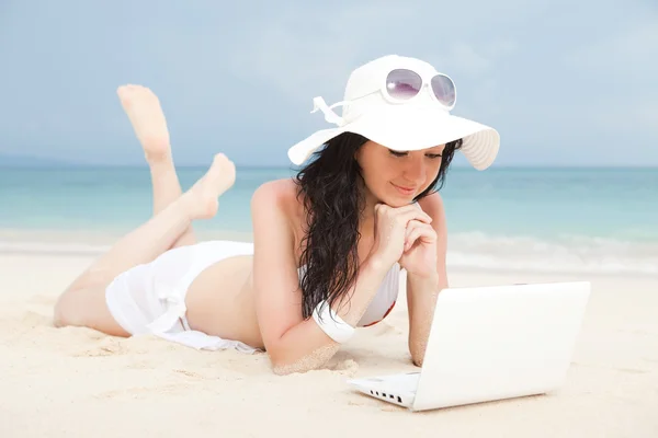 Mujer linda con portátil blanco en la playa de verano —  Fotos de Stock