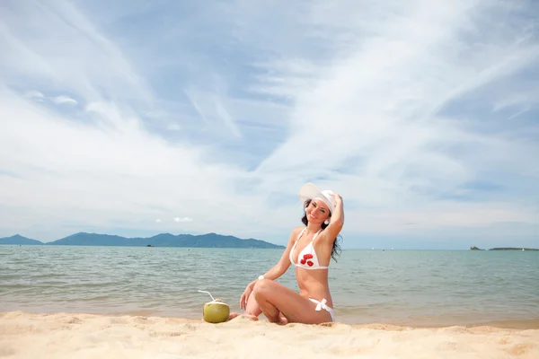 Giovane donna di moda con cocco sulla spiaggia — Foto Stock