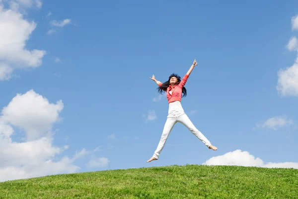 かなり若い女性の緑の草にジャンプ — ストック写真