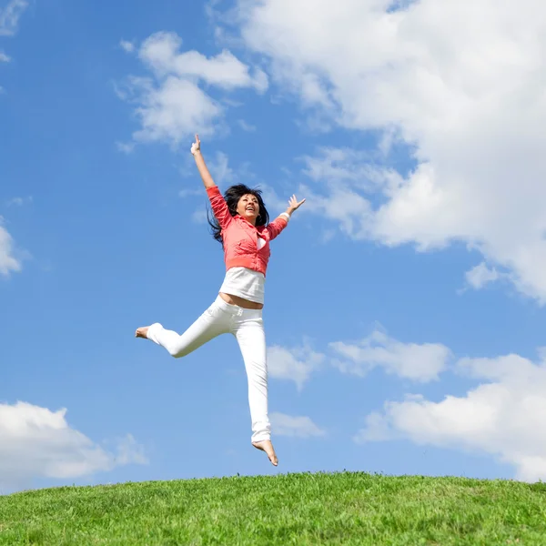 Mulher muito jovem pulando na grama verde — Fotografia de Stock