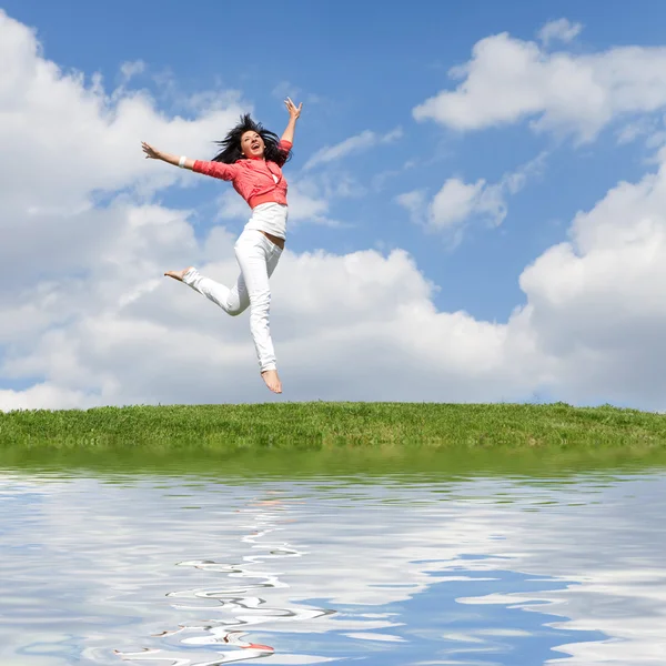 Красива молода жінка стрибає на зеленій траві — стокове фото